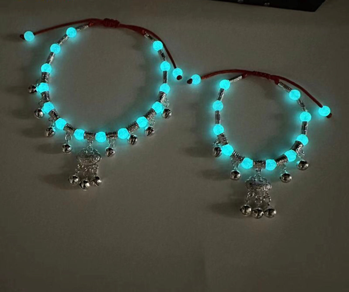 Women's vintage ethnic-style anklet featuring a red braided cord, a "Longevity Lock" charm, and Tibetan silver bells that jingle, accented with a glow-in-the-dark stone.